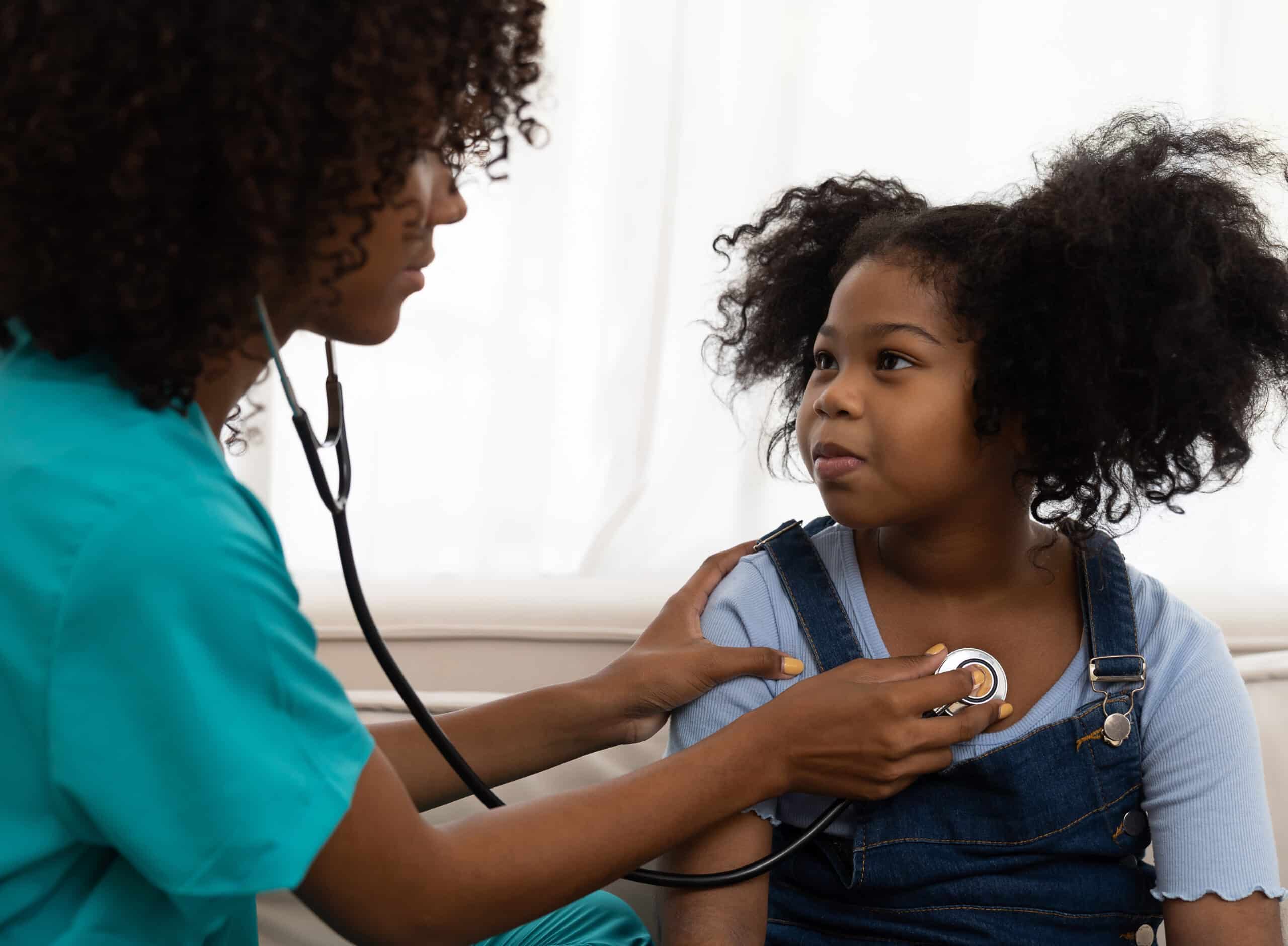 female doctor examining kid child girl by stethoscope at hospita
