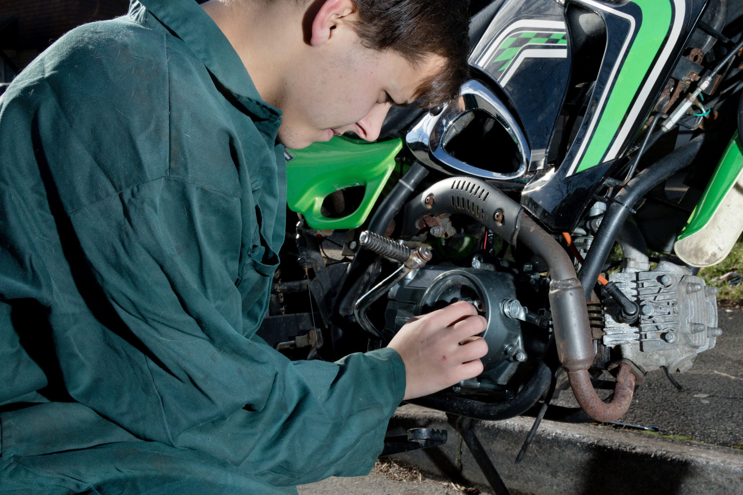 teenage mechanic working on a motorbike