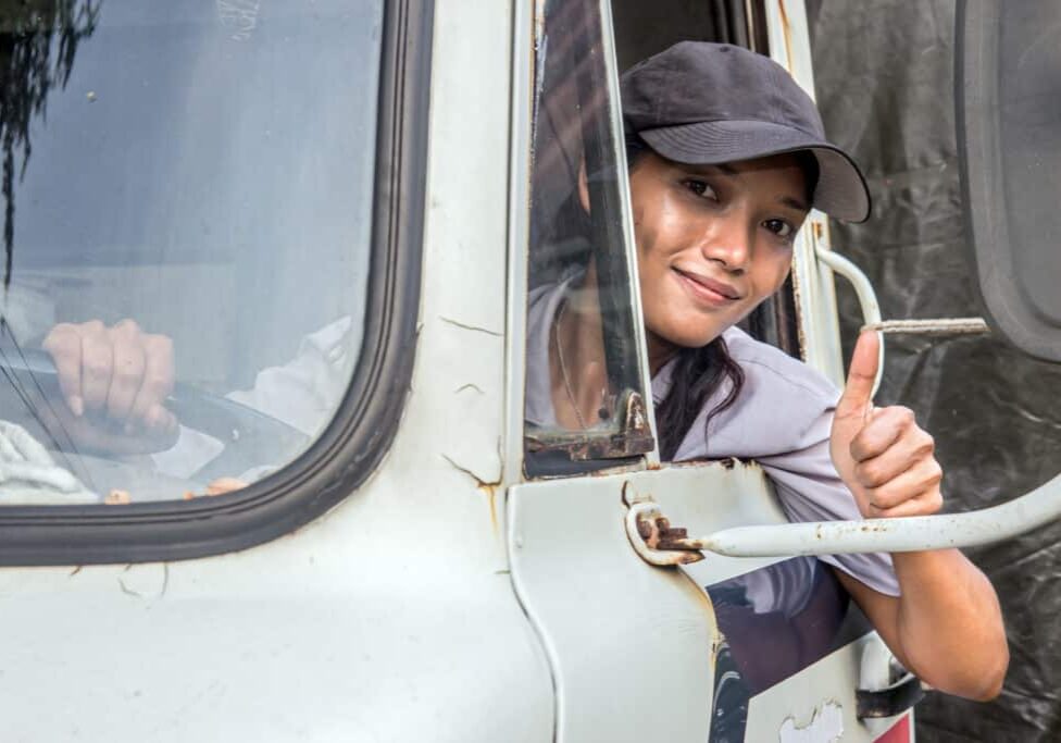 woman truck driver looking out the window with thumb up gesture