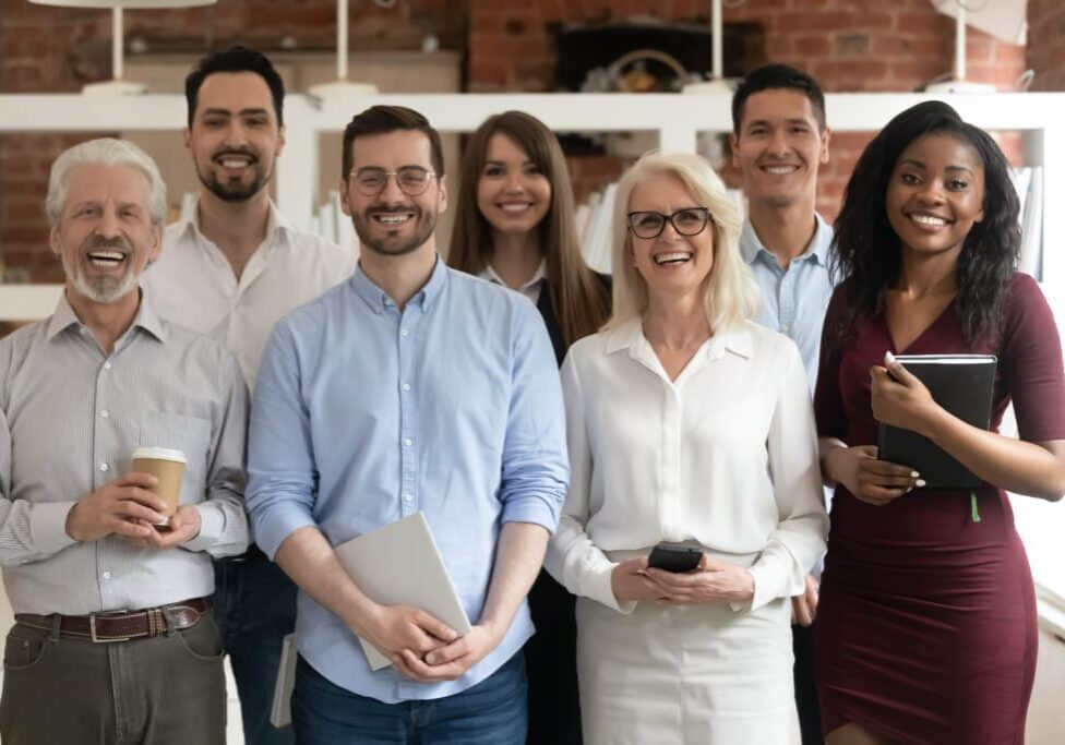 happy diverse business team standing in office looking at camera happy business team standing in office looking at camera