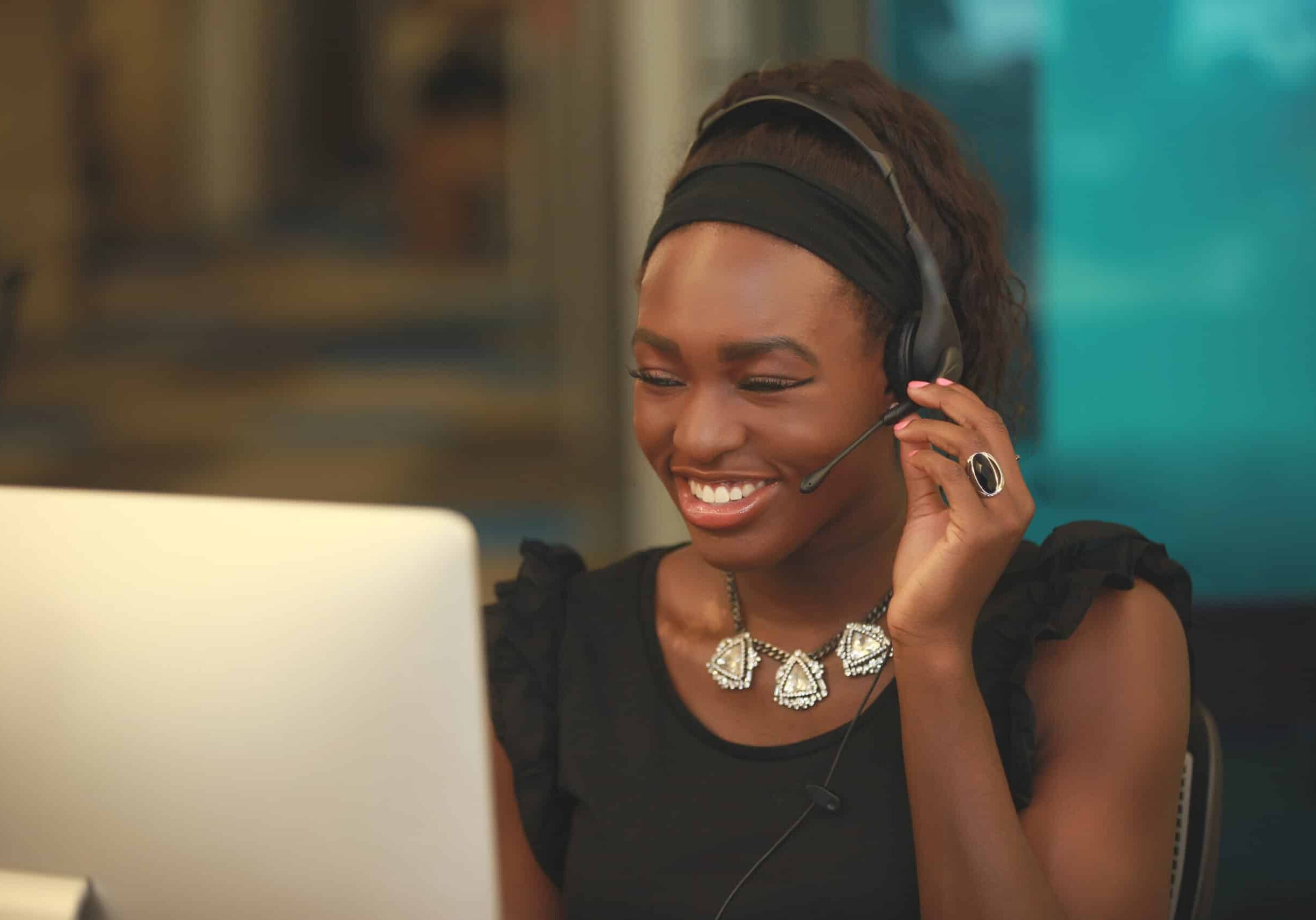 smiling woman in headset working on computer smiling woman in headset working on computer