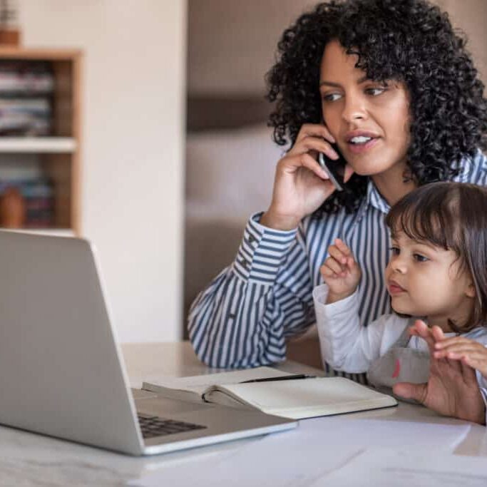 busy mother and entrepreneur working at home with her daughter